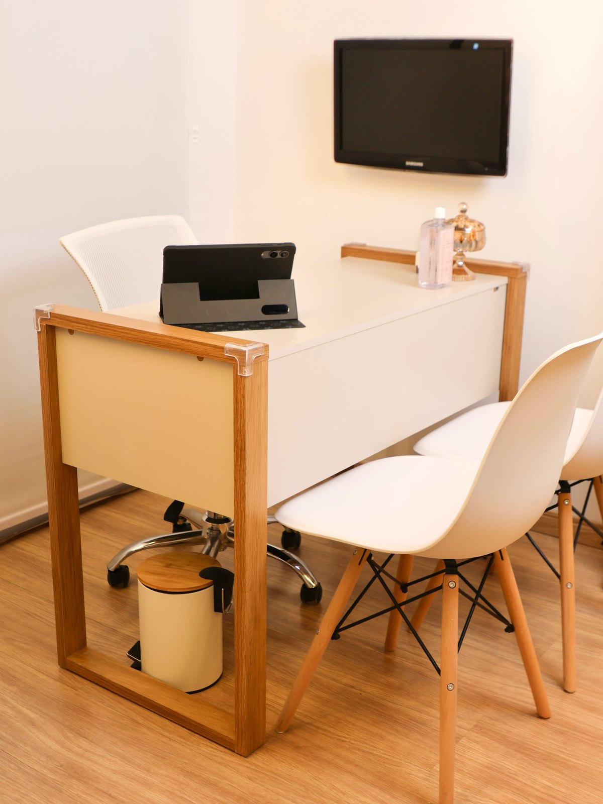 Consultório multidisciplinar com mesa de atendimento, cadeiras e TV